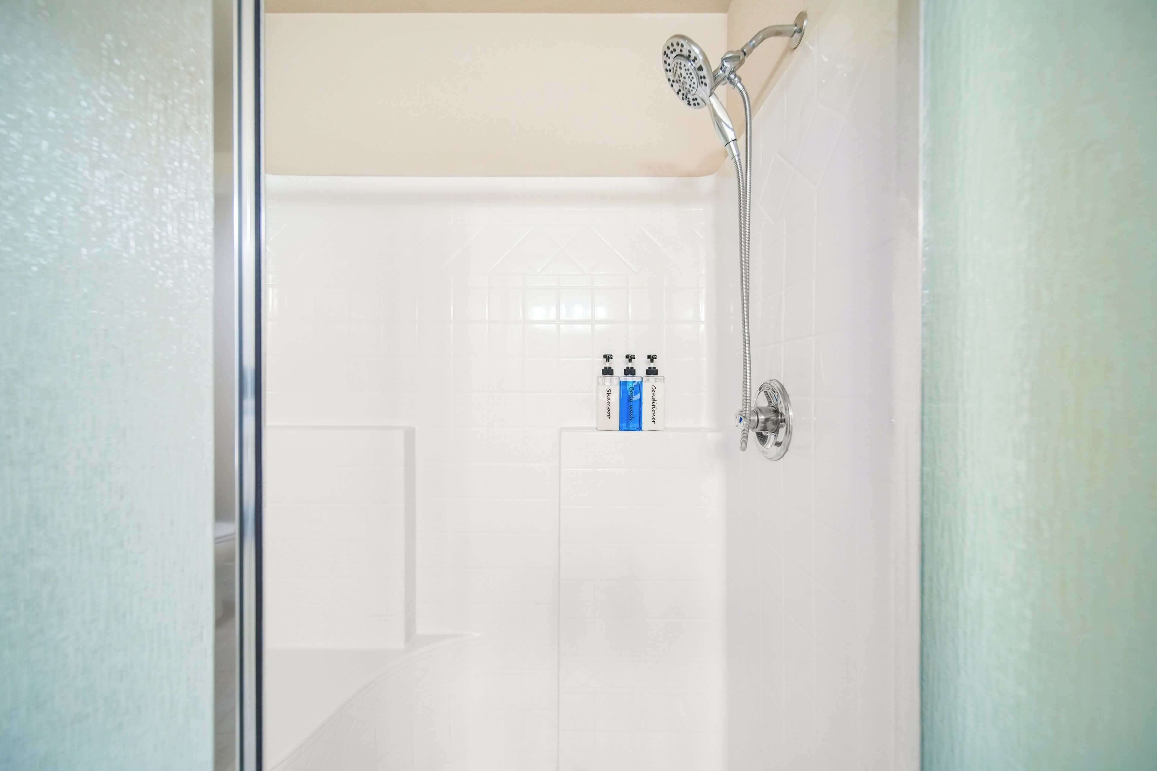 A bathroom with a shower, a toilet, and a sink.