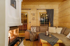 A cozy living room with a fireplace, a sofa set, and a plaid-patterned table.