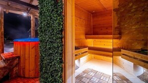 Eine Sauna mit Holzwänden, einer Bank, einem kleinen Pool und einer grünen Wand.