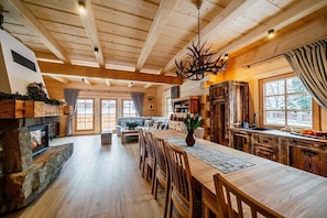 A spacious wooden interior with a dining area, kitchen, and living room. - Comfortable mountain-style house with a SPA area (Murzasichle)