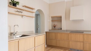 Een keuken met houten kastjes, een spoelbak en een aanrecht.
