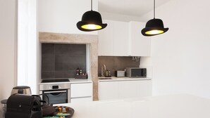 A modern kitchen with a central island, a built-in oven, a microwave, and pendant lighting. - Your Lisbon Home Santa Apolónia (Lisbon)