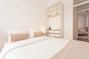 Habitació d'hotel amb llit, un aparador, mirall i armari.