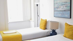Habitació d'hotel amb dos llits, un quadre a la paret i una làmpada.