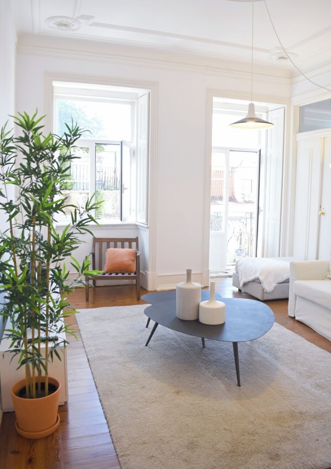 A modern living room with a round coffee table, a sofa, a chair, and a potted plant.
