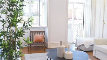 A modern living room with a round coffee table, a sofa, a chair, and a potted plant.