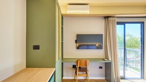 A modern room with a desk, chair, and a TV mounted on the wall. - VILLA NK SUITES (Ubatuba)