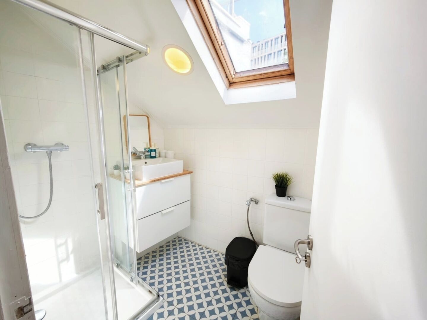 A bathroom with a shower, toilet, and sink.