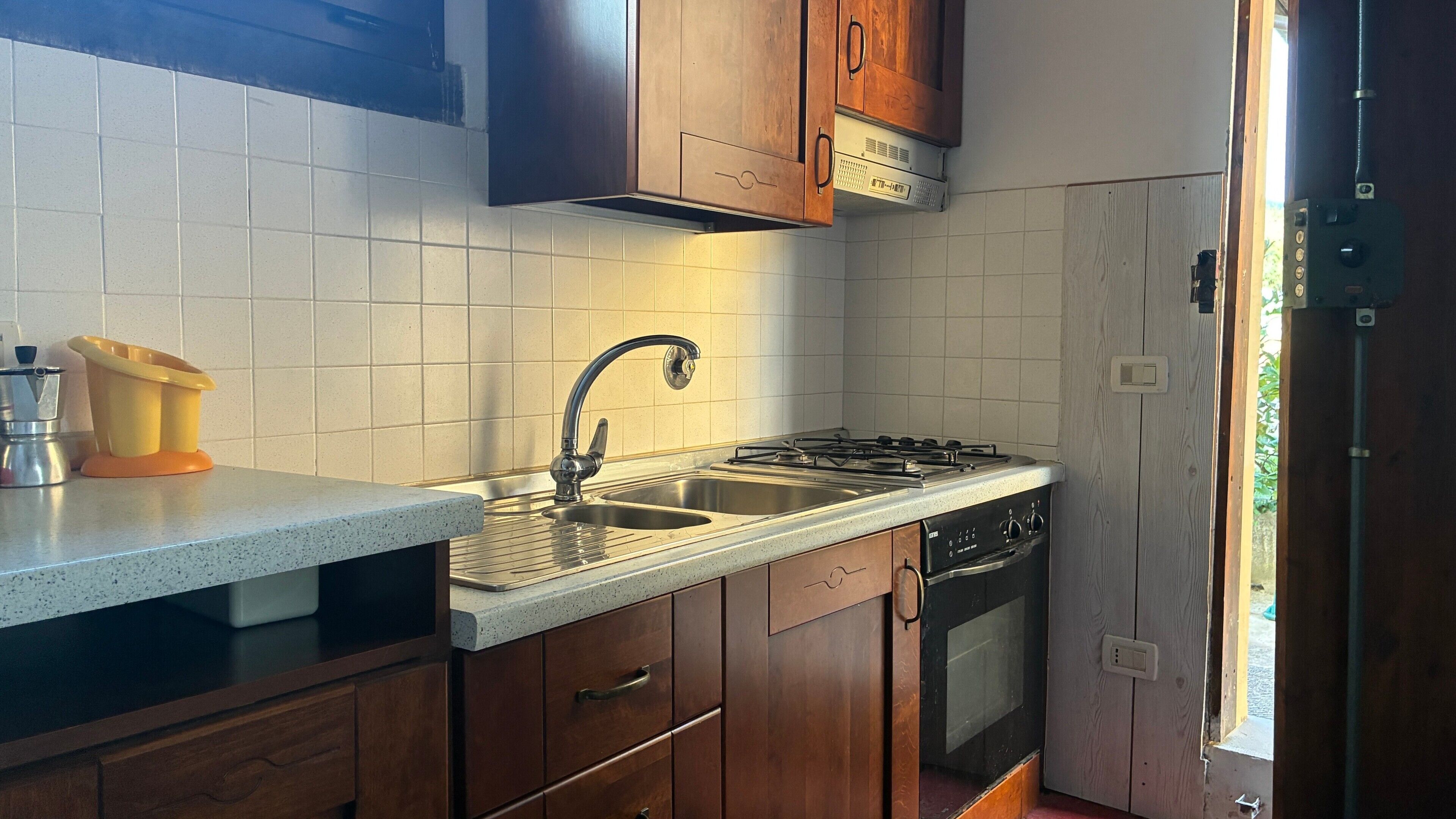 Een koffiezetapparaat/waterkoker, een koelkast, een oven, een kookplaat