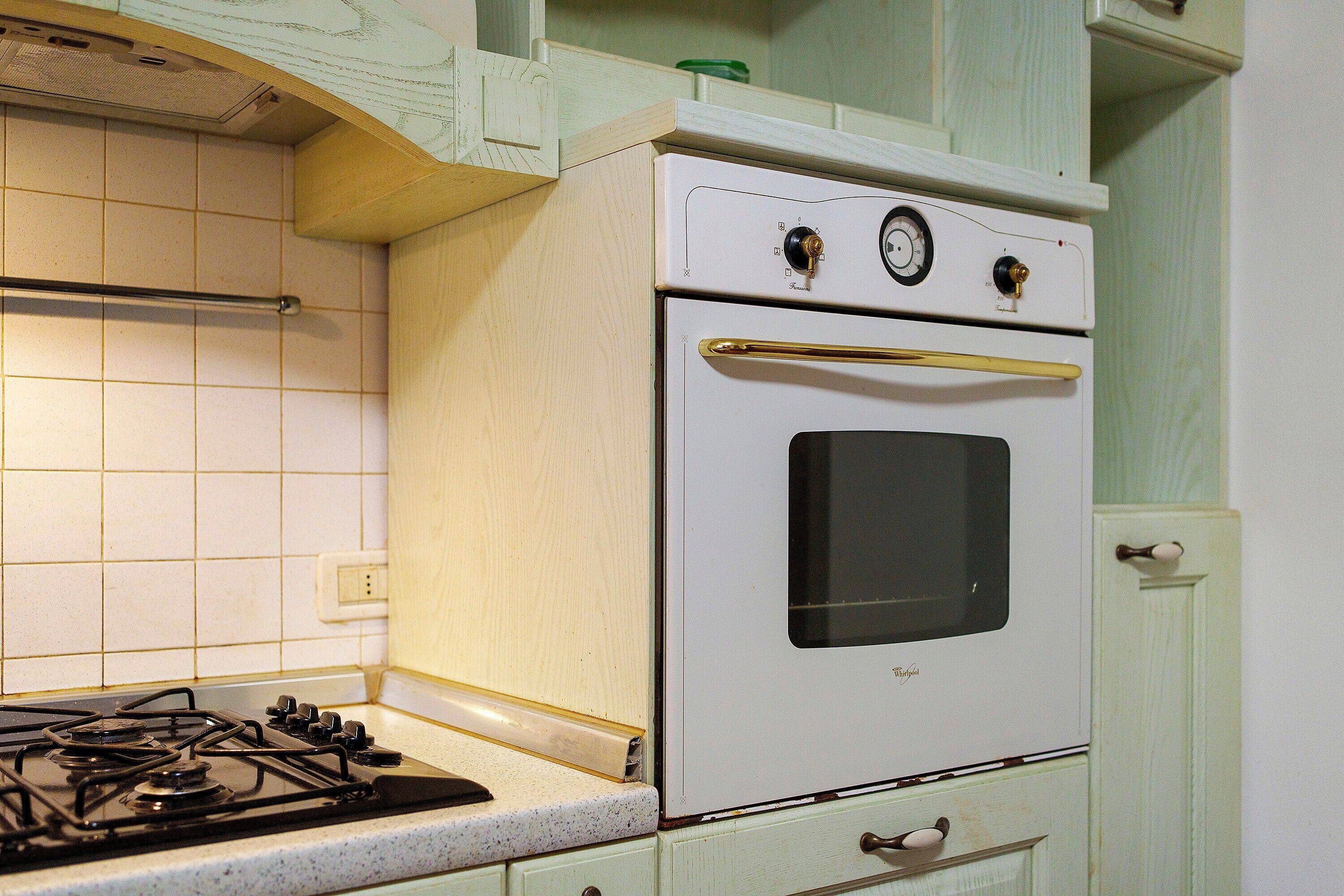Une cuisine avec un fourneau blanc, un brûleur à gaz et un four blanc.