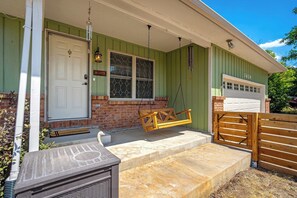 A house with a front porch, a swing, a garage, and a mailbox. - Suncrest Rise! Family Escape Near Fort Carson (Colorado Springs)