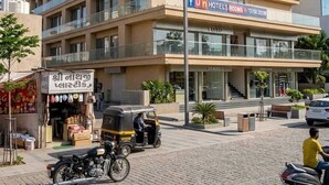Un hotel de varios pisos con un letrero que dice 'habitaciones de hotel divertidas' y un número de contacto.
