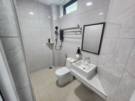 Un baño moderno con inodoro, lavamanos y ducha.