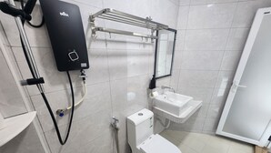 Een moderne badkamer met toilet, wastafel en een DEKA boiler.