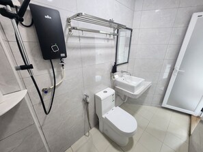Un baño moderno con inodoro, lavamanos y un calentador de agua DEKA.