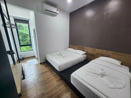 Habitación de hotel con dos camas, ventana con vistas a zonas verdes, unidad de aire acondicionado y piso de madera.