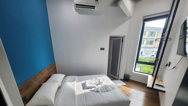 Een hotelkamer met een bed, een raam en een deur.