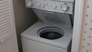 Una unidad compacta de lavadora y secadora en un lavadero pequeño.