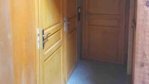 A wooden hallway with two doors, each marked with a letter. - Charlie's house. (Le Monastier-sur-Gazeille)