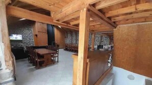 A wooden interior with a dining area, stone walls, and a kitchen area. - Charlie's house. (Le Monastier-sur-Gazeille)