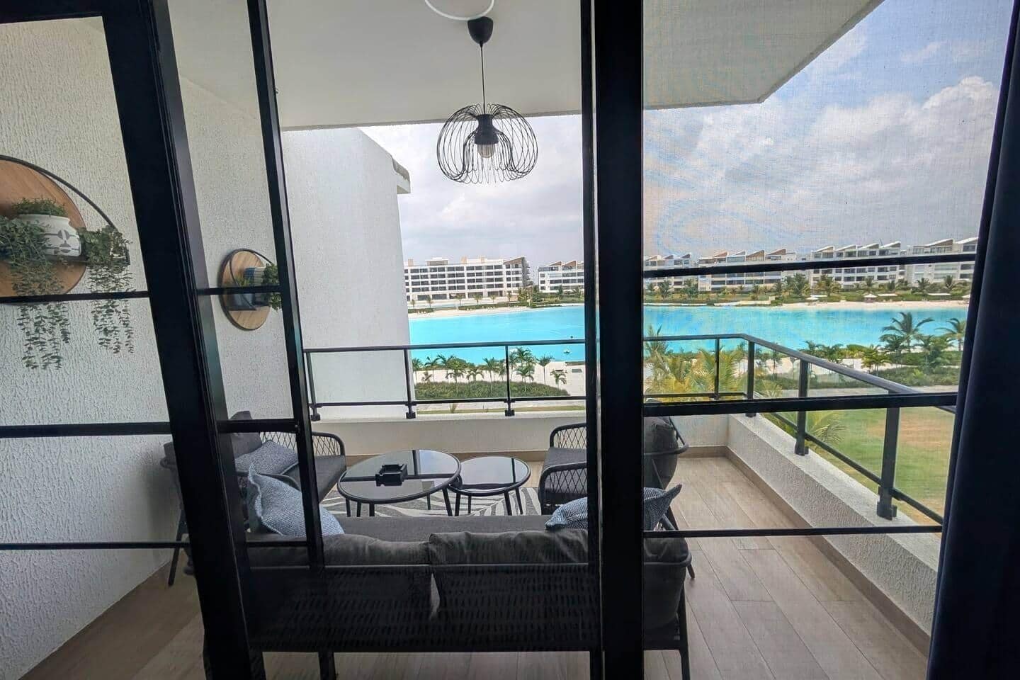 A balcony with a view of a swimming pool and hotel buildings.