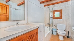 A bathroom with a wooden vanity, a sink, a toilet, and a shower. - 2-bed Villa With Pool, Puerto Pollenca (Pollença)