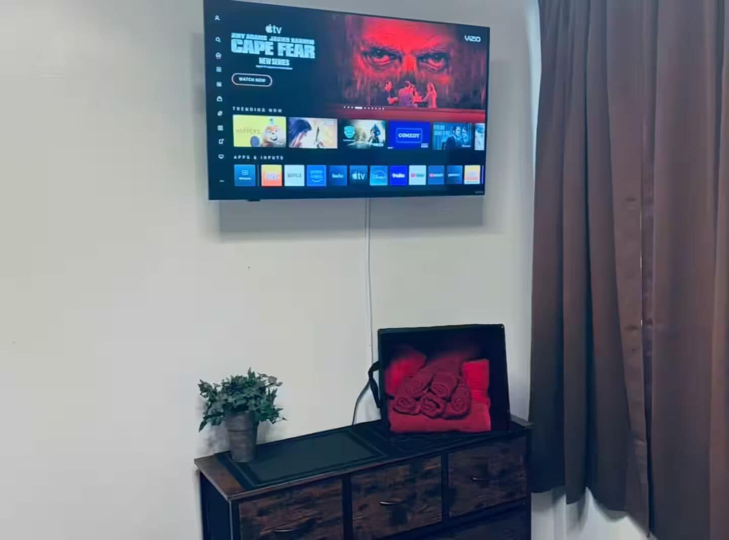 A television mounted on a wall displaying a series titled 'Cape Fear.'