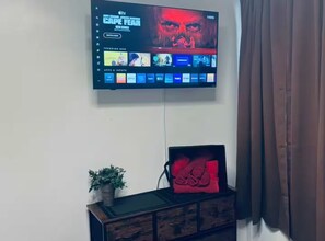 Un televisor montado en la pared mostrando una serie titulada 'Cape Fear'.