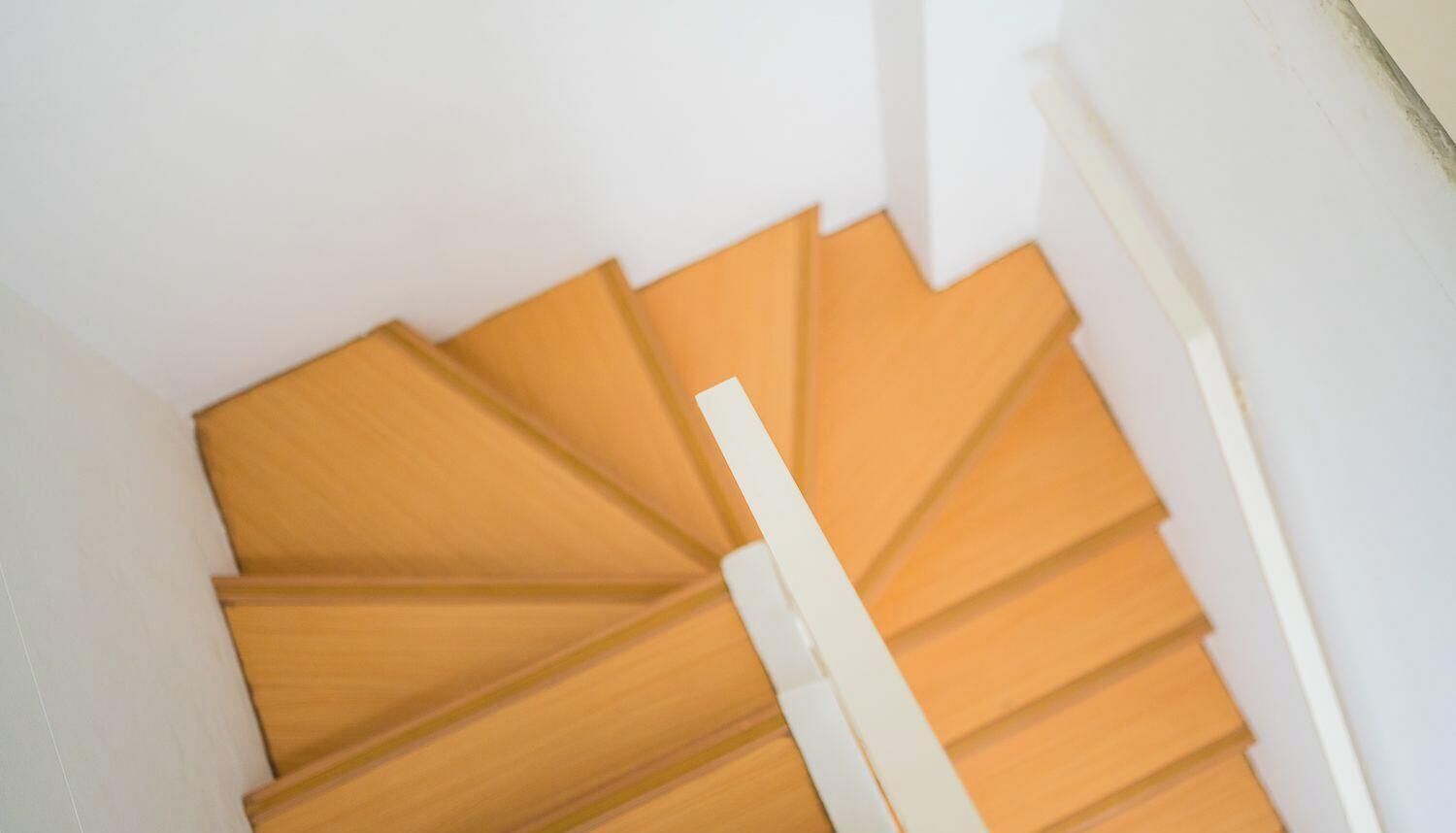 A staircase with wooden steps and white handrails.