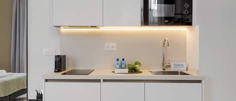 Una cocina americana moderna con horno empotrado, pileta y refrigerador compacto.