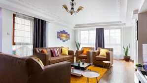 A modern living room with a brown sofa set, a coffee table, and a TV. - Skyline View Palace Apartment (Nairobi)