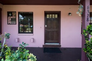 Ein Haus mit brauner Tür, einem Fenster und einem Briefkasten.