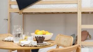 A bunk bed with a breakfast setup including a pitcher, glasses, and a bowl of fruit. - Travel Habitat Loft Parque de Cabecera 2 (Valencia)