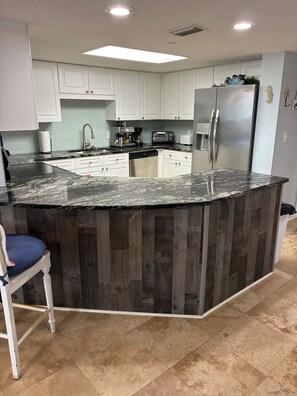 A kitchen with a central island, white cabinets, a stainless steel refrigerator, and a built-in oven. - Spacious 3Bedroom ground floor Condo perfect for big familyFort Walton Beach (Fort Walton Beach)