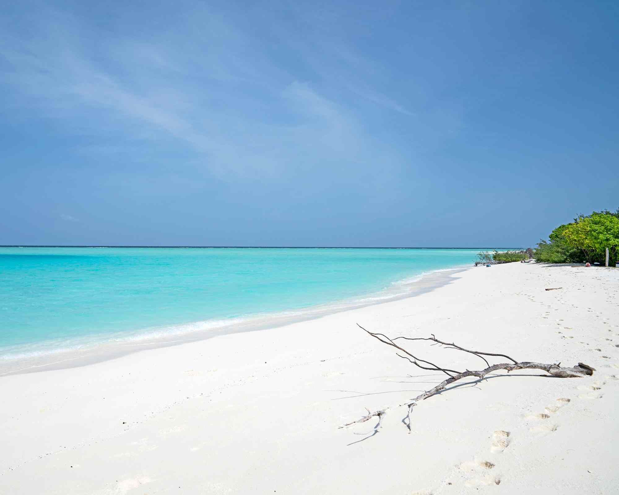 Una playa cerca, arena blanca, sillas reclinables de playa, sombrillas