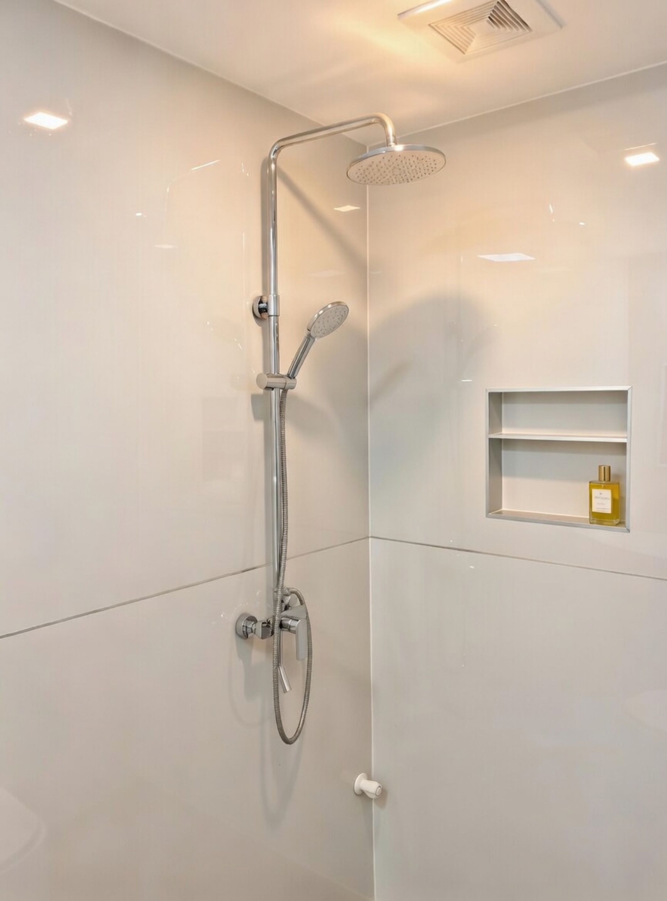 Ducha moderna con cabezal de ducha de mano y cabezal de lluvia instalado en la pared.