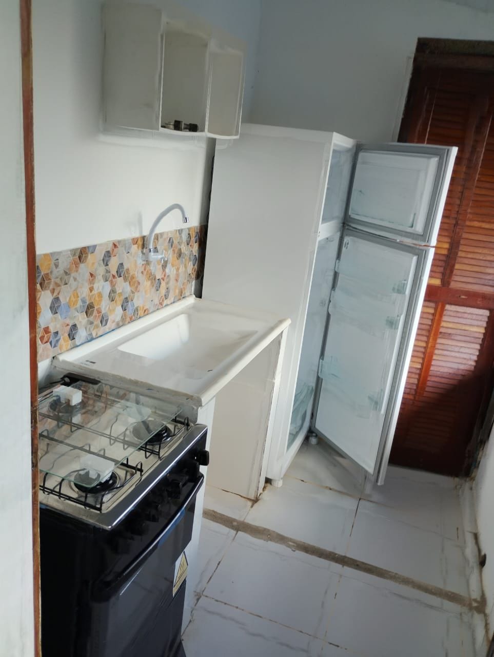 A kitchen with a gas stove, white cabinets, and a tiled backsplash.