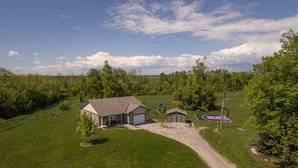 A residential property with a house, a small shed, a basketball court, and a fenced yard. - Rama Ridge with Basketball Court, Hot Tub, Sauna (Orillia)