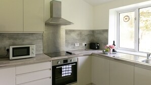 Une cuisine équipée d’un four à micro-ondes, d’une cuisinière, d’un four et d’une fenêtre donnant sur un beau paysage.