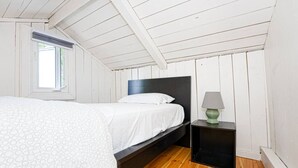 A bedroom with a bed, a nightstand, a lamp, and a window. - Beachfront Cottage #2- Maijac Resort & Marina (Burk`s Falls)