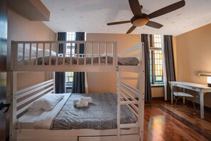 A bunk bed room with a desk and chair, a ceiling fan, and a window with curtains. - The Chapel Retreat with Hot Tub and Game Room (Bluevale)