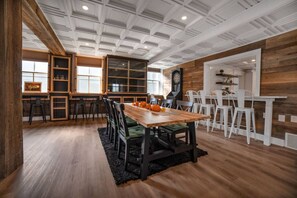 A dining area with a wooden table, chairs, and a kitchen in the background.