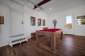 A room with a pool table, white walls, and a door leading outside. - Percy Boom Luxury Home:  Hot Tub/ Sauna/ Game Room (Campbellford)