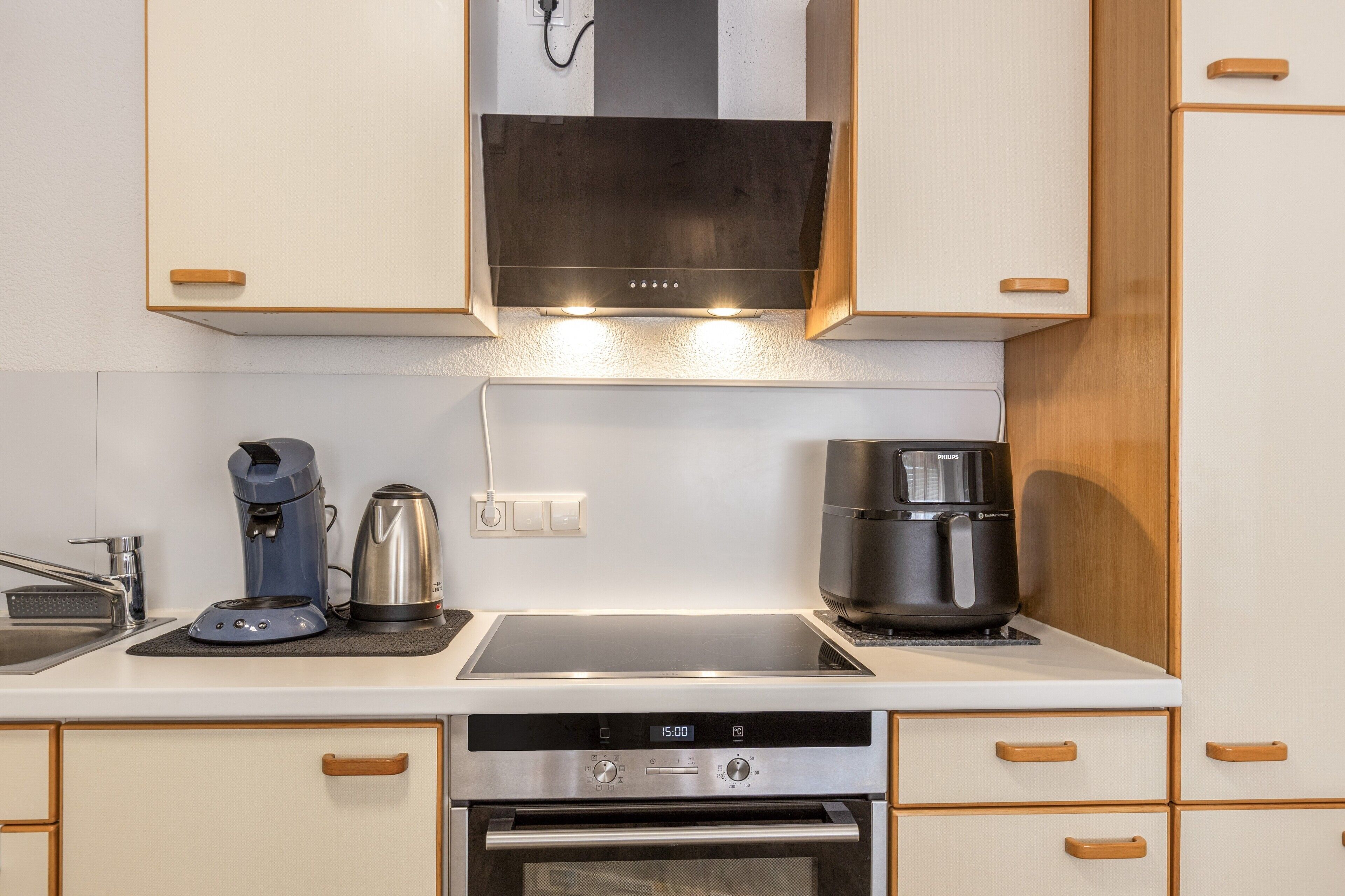 Eine kleine Küche mit Backofen, Kaffeemaschine und Wasserkocher.