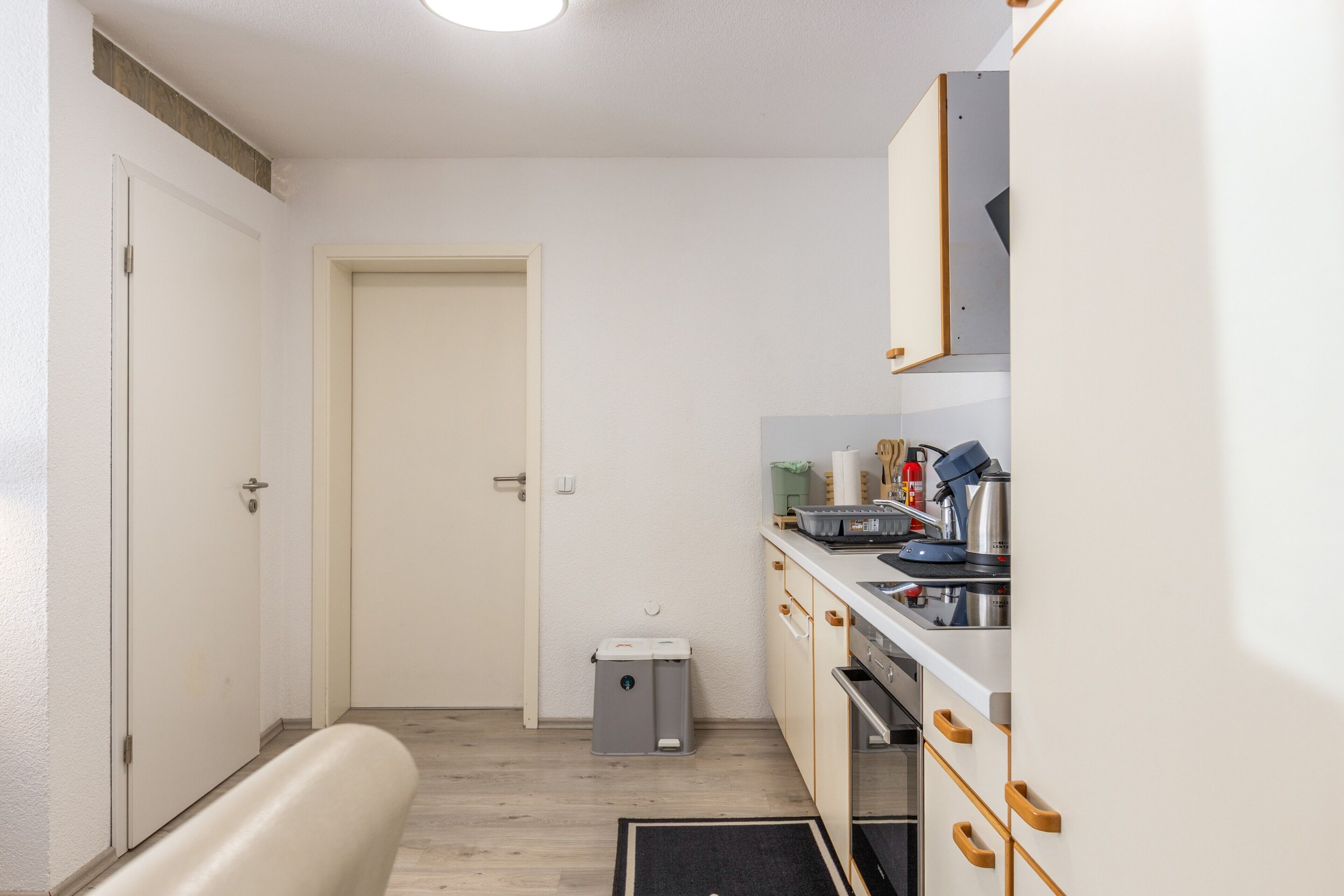 A compact kitchen with a sink, stove, and cabinets.