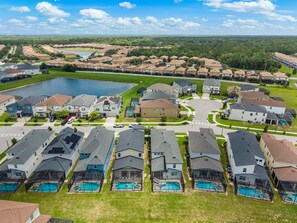 A residential area with houses, a central square, and a body of water. - New Listing! Casa Solara - Private Pool, Spa, Super Close to Disney World! (Kissimmee)