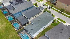 A residential area with multiple houses, each featuring a sloped roof and a swimming pool. - New Listing! Casa Solara - Private Pool, Spa, Super Close to Disney World! (Kissimmee)