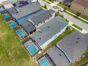 A residential area with multiple houses, each featuring a sloped roof and a swimming pool. - New Listing! Casa Solara - Private Pool, Spa, Super Close to Disney World! (Kissimmee)