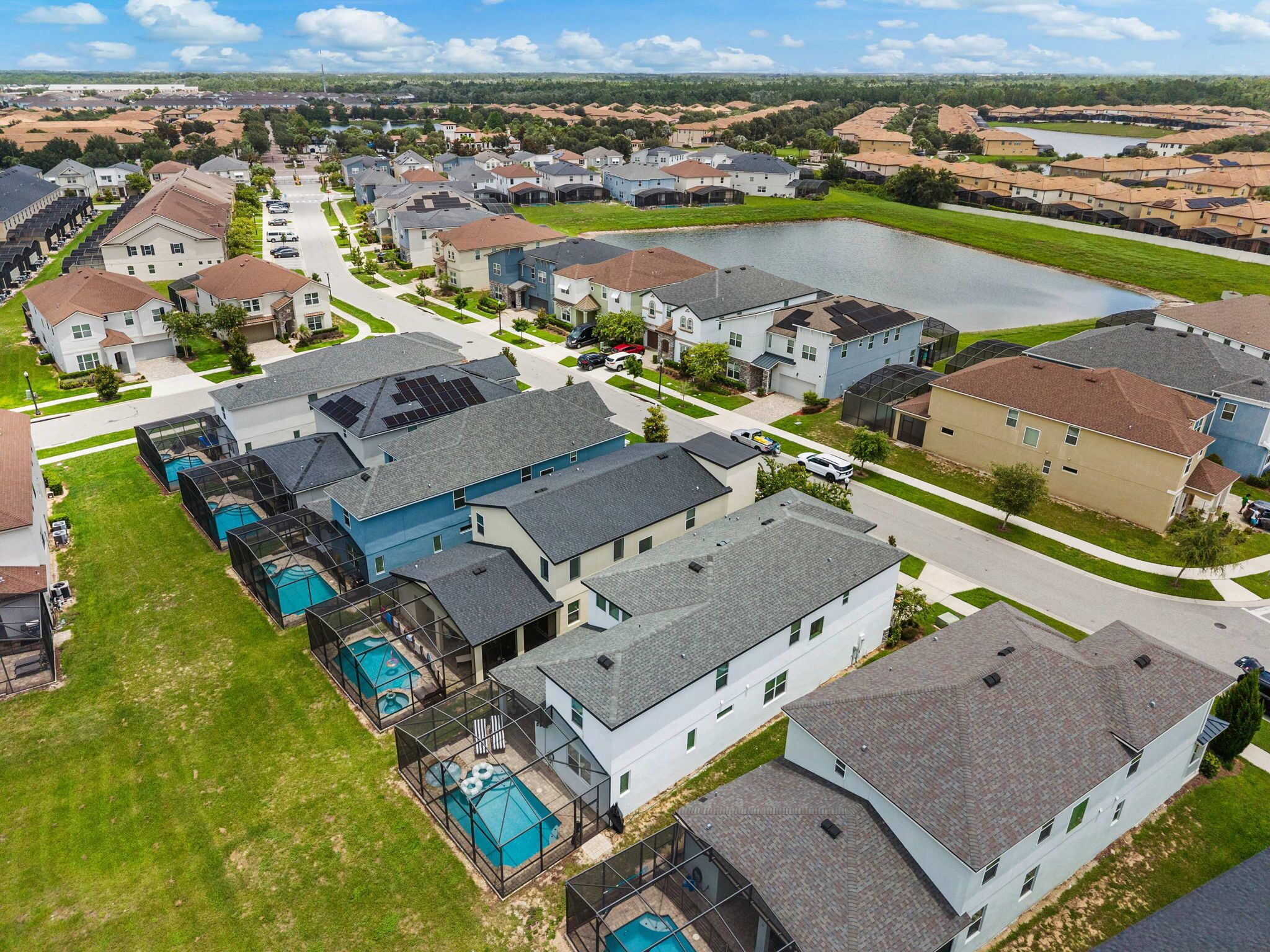 Ett bostadsområde med hus, en swimmingpool och en stor vattenyta.