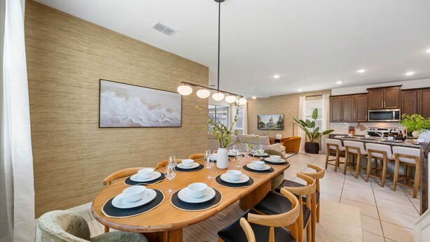 A modern dining area with a wooden table set for four, surrounded by chairs. - New Listing! Casa Solara - Private Pool, Spa, Super Close to Disney World! (Kissimmee)